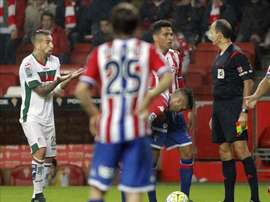 El defensa portugués del Granada, Miguel Lopes (i), protesta al colegiado Alfonso Izquierdo (d), tras ser expulsado durante el encuentro correspondiente a la octava jornada de primera división, disputado frente al Sporting en el estadio del Molinón, en Gijón. EFE/Archivo