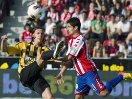 El centrocampista croata del Real Zaragoza Tomislav Dujmovic (i) pelea un balón con el mediocentro del Sporting de Gijón Nacho Cases durante un partido. EFE/Archivo