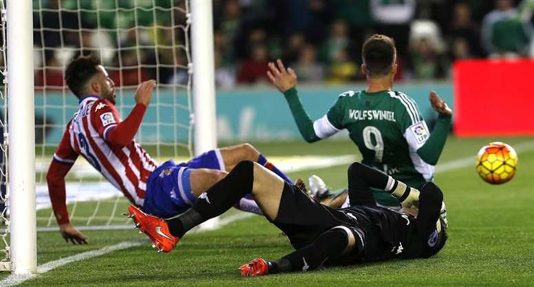 Los jugadores del Sporting de Gijón Álex Menéndez (i) y el portero Iván Cuéllar (c) disputan el balón con el delantero holandés Ricky van Wolfswinkel, del Real Betis, durante un partido. EFE/Archivo