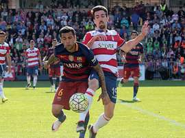 El defensa brasileño del FC Barcelona Dani Alves (i), disputa el balón con el delantero del Granada, Isaac Cuenca (d), durante el partido de la 38 y última jornada de Liga de Primera División jugado en el estadio Nuevo Los Cármenes de Granada, en el que el equipo blaugrana se ha proclamado campeón de la Liga al ganar 0-3 al equipo local. EFE