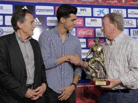 Merino receives a trophy. AFP