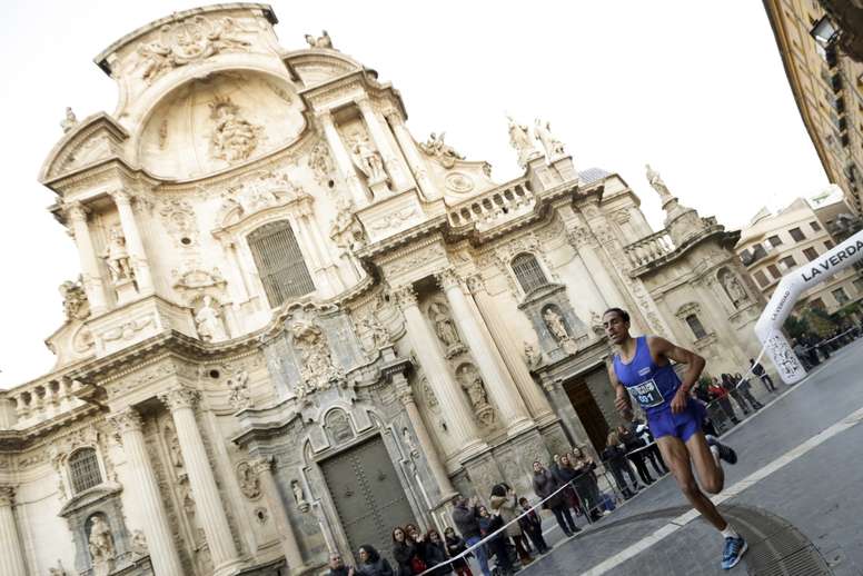 Uno de los participantes pasa ante la catedral de Murcia durante la tradicional carrera de San Silvestre en la ciudad, que ha salido hoy de la Glorieta de España de la capital murciana. EFE