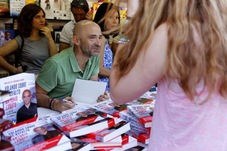 El periodista Antonio Lobato firma ejemplares de libro Volando sobre el asfalto, en la Feria del Libro de Madrid. EFE/Archivo