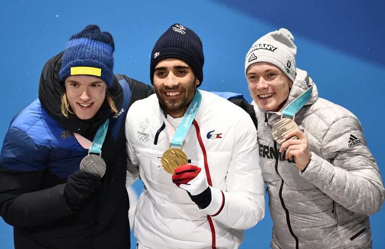 El francés Martin Fourcade (c), el sueco Sebastian Samuelsson (i) y el alemán Benedikt Doll, hoy durante la ceremonia de entrega de medallas de Biatlón. EFE