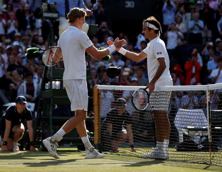 El tenista sudafricano Kevin Anderson (i) estrecha la mano del suizo Roger Federer (d) tras ganar su partido de cuartos de final de Wimbledon disputado en el All England Lawn Tennis Club de Londres, Reino Unido, hoy. EFE