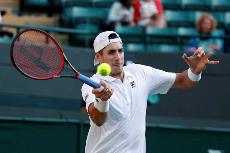 El tenista estadounidense John Isner devuelve la bola al canadiense Milos Raonic, durante el partido de cuartos de final del torneo de Wimbledon, en Londres, Reino Unido. EFE