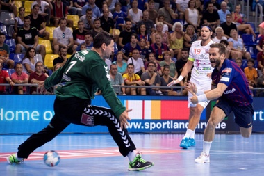El jugador del FC Barcelona Víctor Tomás (d) anota un gol ante el portero del Vezsprem, Arpad Sterbik (i), durante el partido de la segunda jornada de la liguilla de la Liga de Campeones de Balonmano. EFE