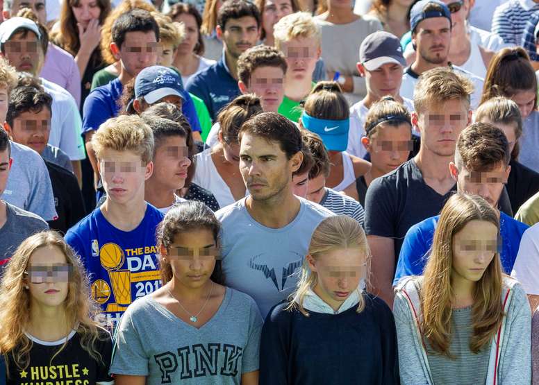 El tenista Rafael Nadal, rodeado de alumnos del Nadal Sports Center, en la localidada mallorquina de Manacor, durante el minuto de silencio en memoria de la víctimas de las inundaciones. EFE