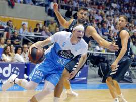 El pívot del Real Madrid, Felipe Reyes (c), defiende la entrada del alero estadounidense del Monbus Obradoiro, Kyle Singler (i), durante el partido correspondiente a la quinta jornada de la Liga Endesa, disputado en el pabellón Fontes Do Sar, en Santiago de Compostela. EFE