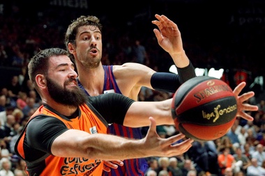 El pivot montenegrino del Valencia Basket, Bojan Dubljevic (i), intenta quedarse el balón ante el jugador croata del Barca Lassa, Ante Tomic, durante el encuentro de la Liga Endesa que disputaron en el pabellón Fuente San Luis, en Valencia. EFE