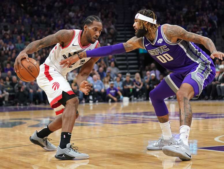 El pívot Willie Cauley-Stein (d) de Sacramento Kings en acción ante el alero Kawhi Leonard (i) de Toronto Raptors, durante un juego de la NBA entre Sacramento Kings y Toronto Raptors, en el Golden 1 Center de Sacramento, California (EE. UU.). EFE