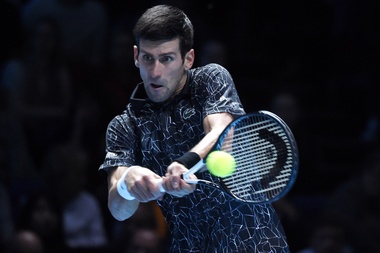 El tenista serbio Novak Djokovic devuelve la pelota al estadounidense John Isner durante la ronda individual masculina en el segundo día del torneo de tenis Finales ATP, en el O2 Arena en Londres (Reino Unido). EFE
