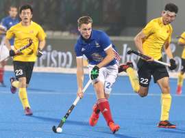 El francés Aristide Coisne (c) intenta zafarse del chino Du Talake (d) durante un partido del Mundial masculino de hockey hierba disputado entre IFrancia y China en el estadio Kalinga de Bhubaneswar (India). EFE