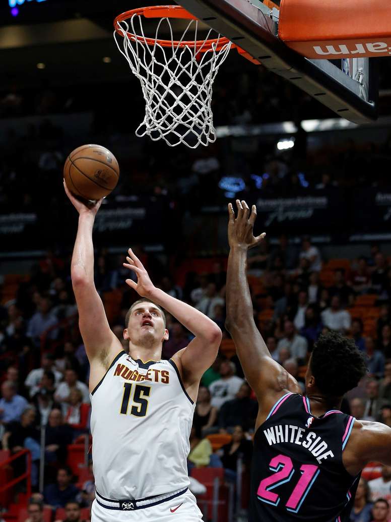 Nikola Jokic (i) de Denver Nuggets en acción ante Hassan Whiteside (d), durante un juego de la NBA entre Denver Nuggets y Miami Heat. EFE