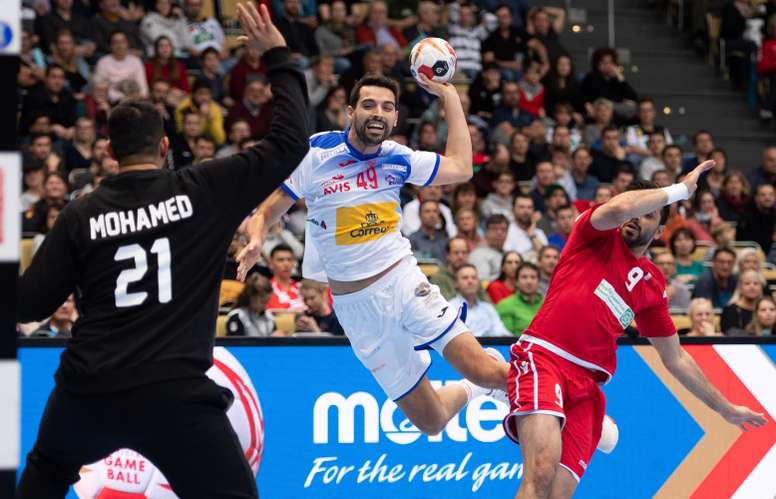 El español Ferrán Sole Sala (C) intenta un lanzamiento junto al jugador de Baréin Hasan Al Samahiji (d) durante un encuentro del Mundial Masculino de balonmano disputado entre Baréin y España en Múnich (Alemania) hoy, 11 de enero de 2019. EFE