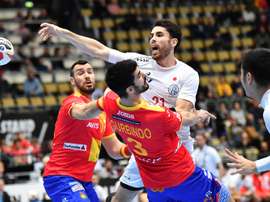 El español Eduardo Gurbindo (c-abajo) en acción contra el japonés Remi Anri Doi (c-arriba) durante un partido del Campeonato Mundial de Balonmano Masculino IHF entre España y Japón en Múnich (Alemania). EFE