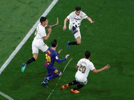 Sevilla players protect the ball from Barcelona forward Lionel Messi. EFE