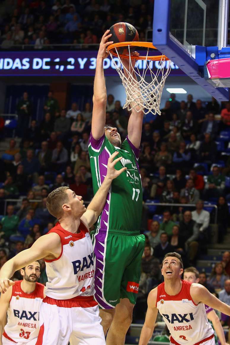 El pivot georgiano del Unicaja Giorgi Shermadini (c) efectúa un mate ante varios rivales del Baxi Manresa durante el partido correspondiente a la jornada 20 de la Liga Endesa y que se disputó en el Palacio de los Deportes José María Martín Carpena. EFE