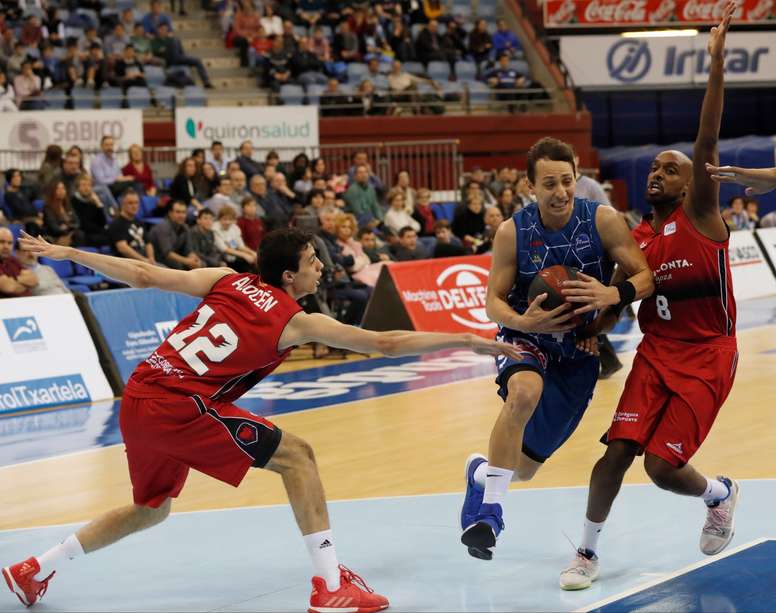 El escolta argentino del Delteco GBC, Federico Van Lacke trata de avanzar ante los jugadores del Zaragoza, Carlos Alocén (i) y Johnny Berhanemeskel. EFE/Archivo