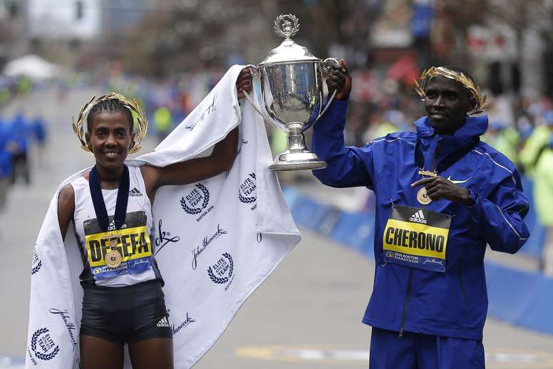 El keniata Lawrence Cherono (d) y su compatriota Worknesh Degefa (i) posan para los fotógrafos tras proclamarse vencedores de la 123 edición del maratón de Boston en la categoría masculina y femenina, respectivamente, este lunes en Boston, Massachusetts, Estados Unidos. EFE