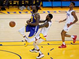 El jugador de los Warriors de Golden State Draymond Green (izq) recibe una falta de JayMychal Green (c), de los Clippers de Los Ángeles, durante el quinto partido de las series clasificatorias de la Conferencia Oeste de la NBA, este miércoles 24, en el pabellón Oracle Arena de Oakland, California (Estados Unidos). EFE
