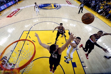 Stephen Curry (c) de los Golden State Warriors en acción contra Zach Collins (i) de Portland Trail Blazers durante su primer juego de las finales de la Conferencia Oeste de la NBA en el Oracle Arena de la ciudad de Oakland, California (EE.UU.). EFE