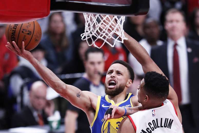 El jugador de los Golden State Warriors Stephen Curry (i) en acción durante el encuentro contra los Trail Blazers de Portland. EFE