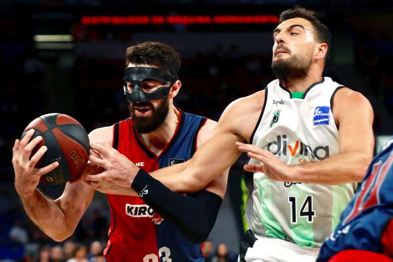 El pívot georgiano del Kirolbet Baskonia Thornike Shengelia (i) lucha con el escolta de Divina Seguros Joventut Albert Ventura, durante el partido aplazado, correspondiente a la jornada 33 de la Liga Endesa, que se disputa este miércoles en el pabellón Fernando Buesa, en Vitoria. EFE
