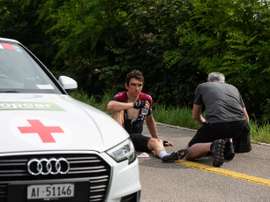 El ciclista británico Geraint Thomas (i), del equipo INEOS, permanece en el suelo tras haber sufrido una caída en la cuarta etapa de la Vuelta a Suiza. EFE