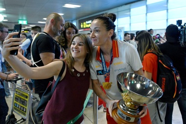 La capitana de la selección española de baloncesto, Laia Palau, posa con una aficionada y con el trofeo del Eurobasket femenino a su llegada al Aeropuerto Adolfo Suárez Madrid-Barajas, tras proclamarse campeona de Europa -junto al resto de la selección- en el torneo disputado en Serbia y Lituania. EFE/ Fernando Villar