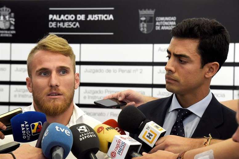 El futbolista, Samu Saiz (i), responde a los medios de comunicación, junto a su abogado, Juan Gonzalo Ospina (d), a su salida del Palacio de Justicia de Huesca, tras prestar declaración por su posible implicación en la operación Oikos de apuestas en el fútbol español, donde él y los jugadores Carlos Martín Briones y Borja Gómez, han negado su relación con el supuesto fraude. EFE/ Javier Blasco