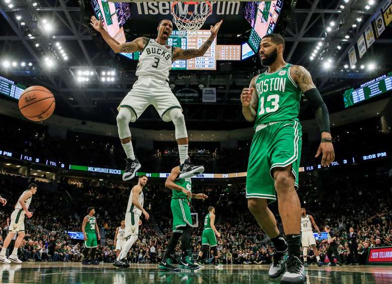 El escolta de los Milwaukee Bucks, George Hill (i), reacciona cuando anota al lado del delantero de los Celtics de Boston Marcus Morris (d) durante un partido. EFE/ Tannen Maury/Archivo