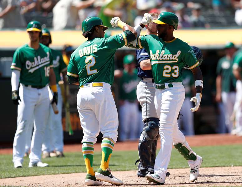 Oakland Athletics Jurickson Profar (R) is greeted at home plate by Oakland Athletics Khris Davis (C) after hitting a two-run home run off Seattle Mariners relief pitcher Matt Festa during the eighth inning of their MLB game at the Oakland Coliseum in Oakland, California, USA, 17 July 2019. (Estados Unidos) EFE/JOHN G. MABANGLO