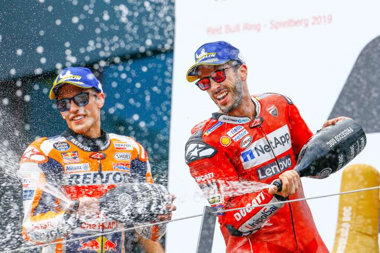 El vencedor de la carrera de MotoGP Andrea Dovizioso celebra junto al segundo clasificado, Marc Márquez, en el podio del GP de Austria. EFE/Archivo