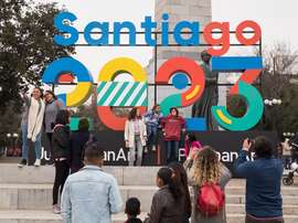 Un grupo de personas se toma fotografías este sábado frente a un cartel que anuncia la celebración de los juegos Panamericanos y Parapanamericanos 2023, en Santiago (Chile) durante el lanzamiento oficial de la capital como sede. EFE/Alberto Valdes