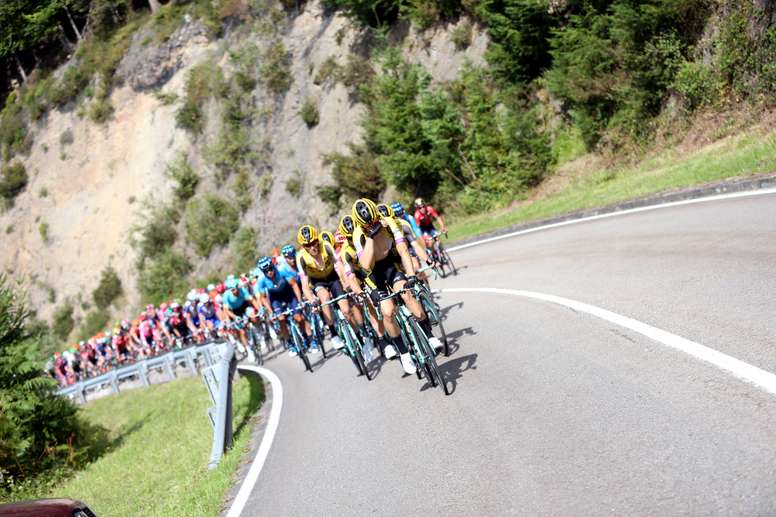 El pelotón rueda a su paso por la localidad asturiana de Pravia durante la decimosexta etapa de la Vuelta a España 2019. EFE/Javier Lizón