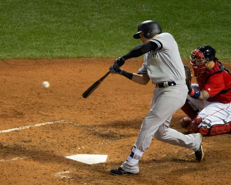 El colombiano Gio Urshela (c), tercera base de los Yanquis de Nueva York, fue registrado este lunes al conectarle un jonrón a los Medias Rojas de Boston, ante la mirada del receptor Christian Vazquez (d), durante la séptima entrada de un partido de la MLB, en el Fenway Park de Boston (Massachusetts, EE.UU.). EFE/CJ Gunther