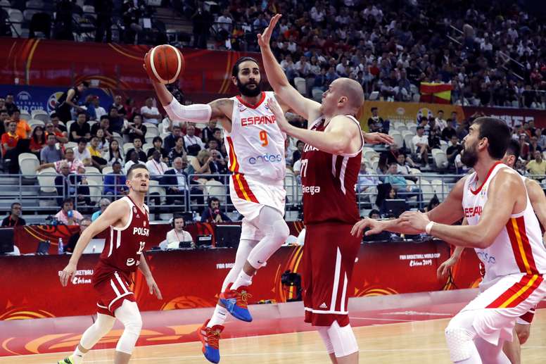 El base de la selección española Ricky Rubio (i) entra a canasta ante la defensa del ala-pívot polaco Damian Kulig (c) durante el partido de cuartos de final del Mundial de Baloncesto de China, disputado este martes en el Shangai Oriental Sports Center de la ciudad china de Shangai. EFE/Juan Carlos Hidalgo