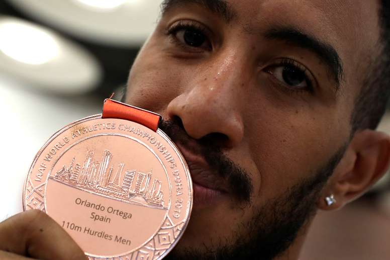 El atleta Orlando Ortega muestra su medalla de bronce a la llegada de la selección española de atletismo de los Mundiales de Doha, este lunes en el Aeropuerto de Madrid-Barajas. EFE/J.J. Guillén