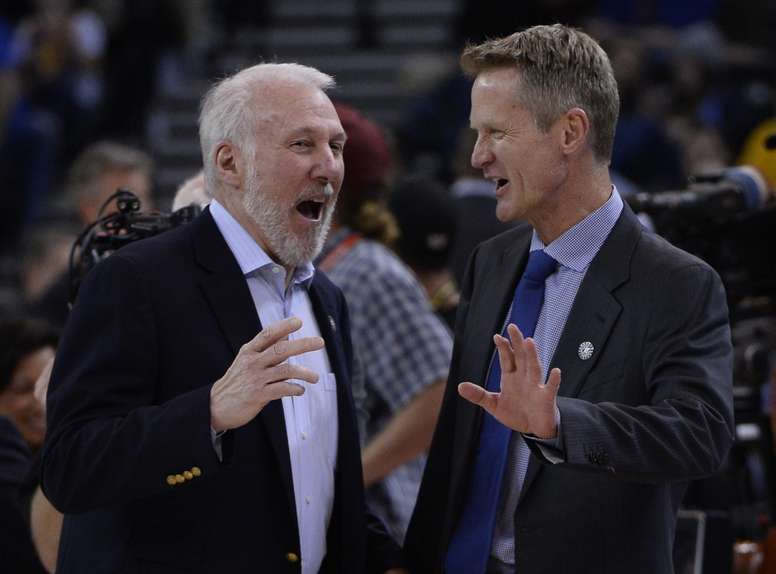 En la imagen un registro del entrenador de los Spurs de San Antonio, Gregg Popovich (i), al hablar con el entrenador de los Warriors de Golden State, Steve Kerr (d), previo a un partido de la NBA. EFE/John G. Mabanglo/Archivo