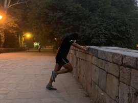 Jatan, un corredor que se prepara para su próxima maratón en los turísticos jardines Lodhi, en Nueva Delhi realiza sus ejercicios diarios con una máscara anti-polución para protegerse durante estas fechas de las nocivas partículas que merodean por la capital india. EFE/ Mikaela Viqueira