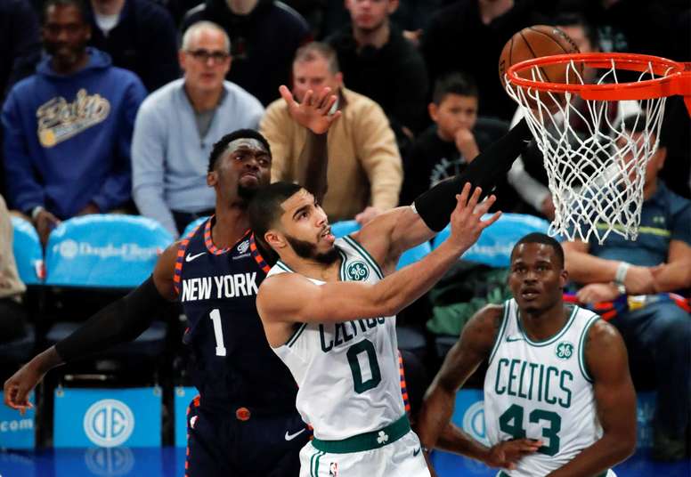 Boston Celtics forward Jayson Tatum (C) tries to put up a shot past a defending New York Knicks forward Bobby Portis (L) in the first half of the NBA basketball game between the Boston Celtics and the New York Knicks at Madison Square Garden in New York, USA, 01 December 2019. EFE/Jason Szenes