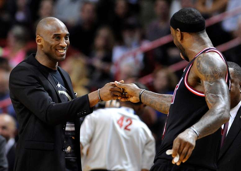 Imagen de archivo del saludo entre Kobe Bryant (i) y LeBron James (d) durante el descanso de un partido de la NBA. EFE/EPA/RHONA WISE/Archivo