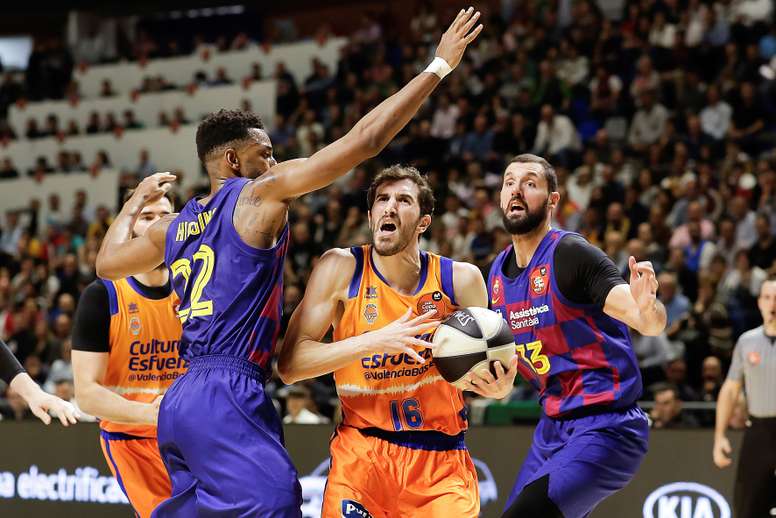 El alero estadounidense del Barcelona Cory Higgins (i) y el ala-pívot Nikola Mirotic (d) defienden al base del Valencia Basket Guillem Vives (c) durante el partido de cuartos de final de la Copa del Rey entre el FC Barcelona Lassa y Valencia Basket disputado en el Palacio de Deportes José Mª Martín Carpena de Málaga, este jueves. EFE/Carlos Diaz