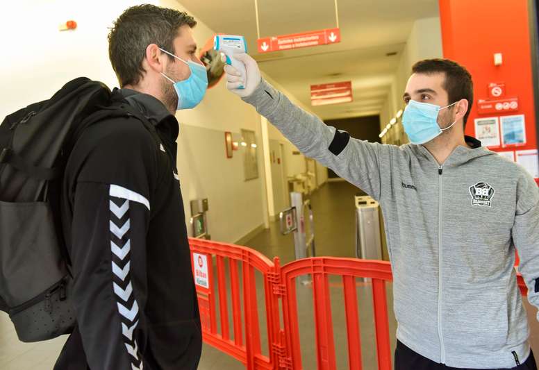 Personal del club toma la temperatura al pívot checo del RETAbet Bilbao Basket, Ondrej Balvin (i), a su llegada al primer entrenamiento del equipo tras el confinamiento por la pandemia del COVID-19. EFE