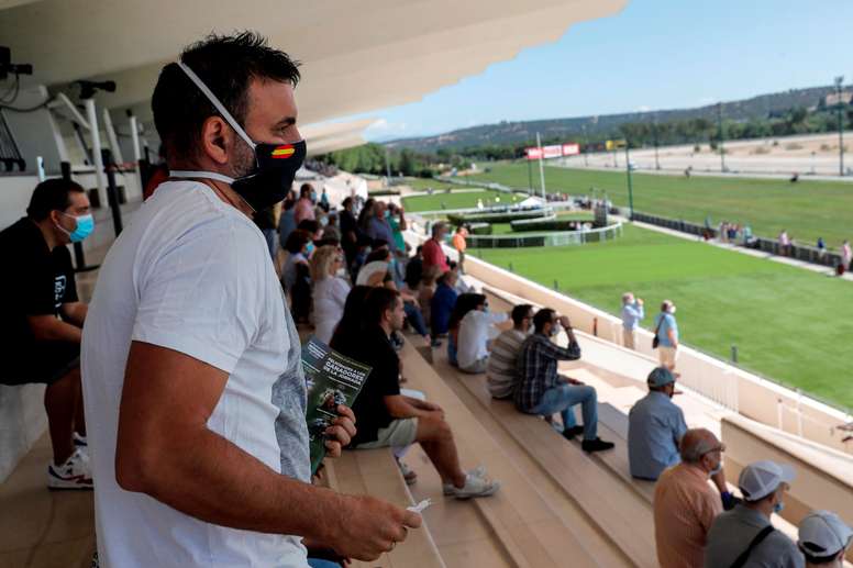 Varias personas este domingo en el <b>Hipódromo</b> de la Zarzuela de Madrid, que abre sus puertas al público general con un aforo del 60 % después de que el pasado 14 de junio las carreras volvieran después de casi tres meses de cierre, pero sin asistentes en las gradas. EFE/ Chema Moya