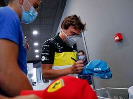 GREl piloto Fernando Alonso firma una gorra a un aficionado este miércoles en el museo que tiene en el municipio asturiano de Llanera. El español Fernando Alonso ha anunciado que en 2021 volverá a competir en el Mundial de Fórmula Uno con Renault, con la que ganó sus dos títulos mundiales -2005 y 2006-, en la que será su tercera etapa en la escudería francesa. EFE/J.L. Cereijido