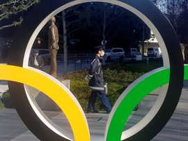 Un policía protegido por una máscara para evitar posibles contagios pasea junto a los anillos olímpicos instalados en Tokio. EFE/DEMÓFILO PELÁEZ/Archivo