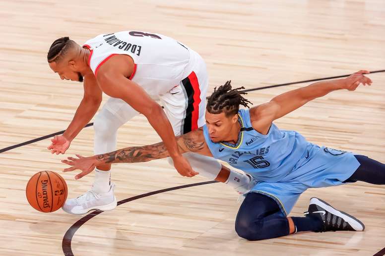 CJ McCollum (i), guardia de Trail Blazers de Portland, en acción contra Brandon Clarke (d), pívot de los Grizzlies de Memphis. EFE/EPA/ERIK S. LESSER