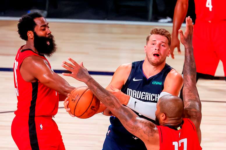 El jugador de los Dallas Mavericks Luka Doncic (c) y los de los Houston Rockets P.J. Tucker (d) y James Harden (i) durante el partido. EFE/EPA/ERIK S. LESSER